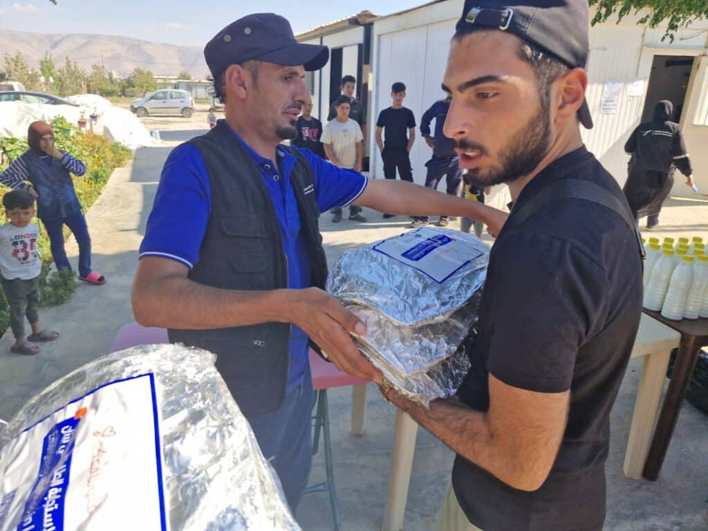 Men giving out supplies to people in Lebanon